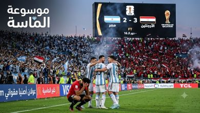 صورة واقعية عالية الجودة تظهر ليونيل ميسي محتفلًا ومحمد صلاح متأثرًا بعد نهاية مباراة الأرجنتين ومصر في كأس العالم 2026 مع شعار موسوعة الماسة في الزاوية.