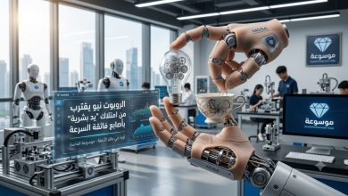 صورة واقعية توضح يد الروبوت نيو المتطورة وهي تمسك بمصباح كهربائي وفنجان قهوة بدقة متناهية تحاكي اليد البشرية مع ظهور شعار موسوعة الماسة.